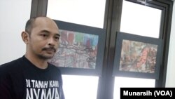 Pelukis dan aktivis Andreas Iswinarto di depan lukisan abstrak yang terinspirasi perjuangan almarhum aktivis Wiji Thukul yang dipamerkan di PUSHAM UII, Banguntapan Bantul Yogyakarta (Foto: Munarsih)