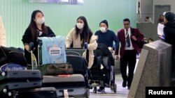 Luego de confirmarse una muerte por Coronavirus en California, el gobernador Newson declaró allí el estado de emergencia el miércoles. En la imagen, pasajeros arriban a Los Ángeles, procedentes de Shanghai, China.