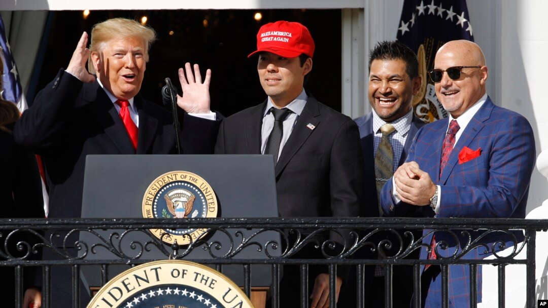 El presidente Donald Trump (izquierda) reacciona mientras el receptor Kurt Zuzuki camina hacia el podio para hablar durante el evento en honor los Nacionales de Washington, ganadores de la Serie Mundial de Beísbol el lunes, 4 de noviembre, de 2019.