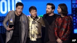 Dan Reynolds, dari kiri, Ben McKee, Daniel Platzman, dan Daniel Wayne Sermon dari Imagine Dragons menerima penghargaan untuk Grup Favorit atau Duo di penghargaan American Music Awards di Microsoft Theater di Los Angeles, 19 November 2017.