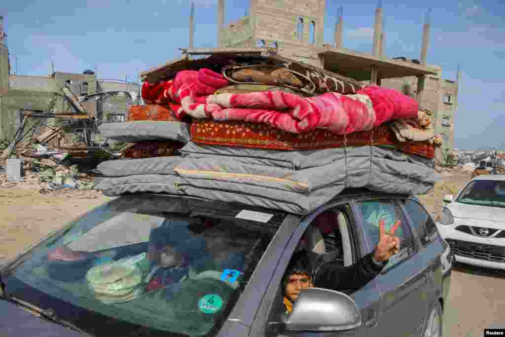 A Palestinian man gestures from a car as he returns with his family to his house, following a ceasefire between Israel and Hamas, in the southern Gaza Strip, Jan. 19, 2025. 