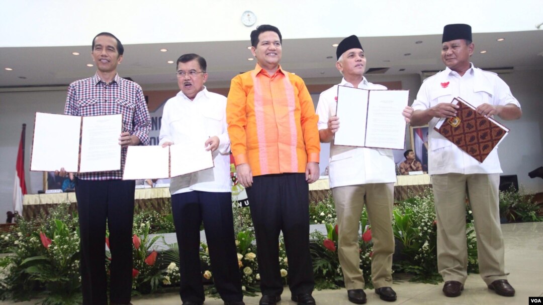 Ketua KPU Husni Kamil Manik (tengah) bersama pasangan Capres-Cawapres Joko Widodo dan Jusuf Kalla (kiri) dan Prabowo Subianto-Hatta Rajasa dalam pengumuman laporan kekayaan di Jakarta, Selasa (1/7).