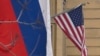 A Russian national tricolor flag flies next to a US national flag sitting on the US embassy building in Moscow on March 13, 2025.