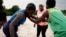 Coach Isabelle Sambou, 43 , two-time Olympian and nine-time African wrestling champion, center, explains moves to young women during a wrestling training, in Mlomp, southern Senegal, July 10, 2024. 