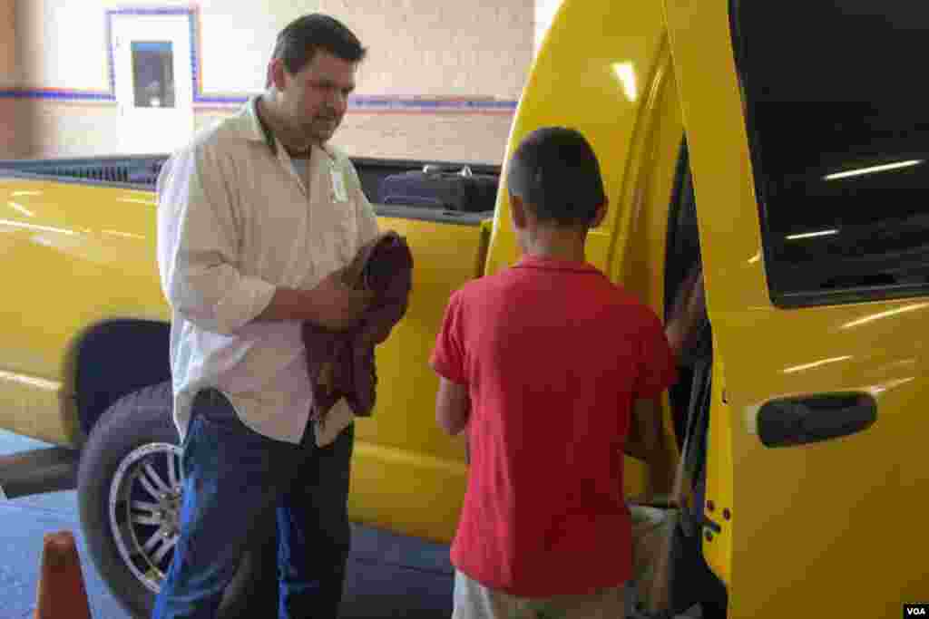 Pastor Mario Garcia loads a migrant family into his truck to get them food and a shower after they were released from federal detention, at the Holding Institute, Laredo, Texas, Aug. 12, 2014. (VOA / V. Macchi)