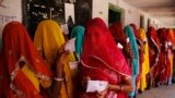 Indian village women line up outside a polling station to cast their votes during Rajasthan state assembly elections at Devnagar village near Ajmer.