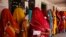 Indian village women line up outside a polling station to cast their votes during Rajasthan state assembly elections at Devnagar village near Ajmer.
