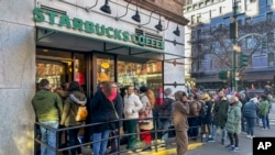 Una fila de personas espera en una cafetería Starbucks en Nueva York el 23 de noviembre de 2023.