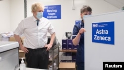 FILE - British Prime Minister Boris Johnson watches as a dose of the AstraZeneca COVID-19 vaccine is prepared by a nurse, at a coronavirus vaccination site in north London, Britain, Jan. 25, 2021.