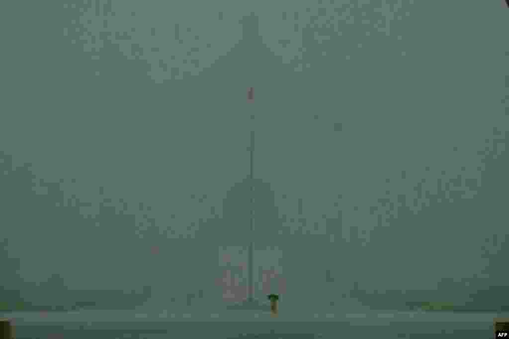 A man walks in heavy rain caused by Tropical Storm Choi-Wan in front of the Chiang Kai-shek Memorial Hall in Taipei.