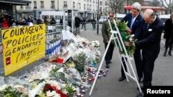 Menlu AS John Kerry (kiri) didampingi Menlu Perancis Laurent Fabius di lokasi serangan teror di supermarket Yahudi di Paris (16/1).