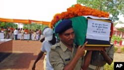 Policemen carry the flag-draped coffin of their colleague, one of nine officers killed by dozens of suspected Maoist rebels, on the outskirts of Raipur, capital of the eastern Indian state of Chhattisgarh, May 24, 2011