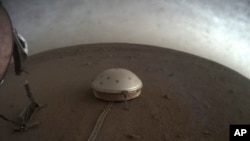 This April 25, 2019 photo made available by NASA shows the InSight lander's dome-covered seismometer on Mars. On Oct. 1, 2019, scientists released an audio sampling of marsquakes and other sounds recorded by the probe. 