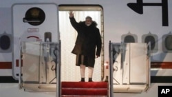 India's Prime Minister Narendra Modi waves from the stairs of his plane upon his arrival at Joint Base Andrews, Md., Feb. 12, 2025. 