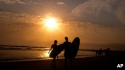 加州洛杉磯威尼斯海灘夕陽下的衝浪者。(2021年6月16日)