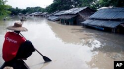 Một người đàn ông chèo thuyền gần ngôi nhà bị ngập lụt ở Nyaung Tone, đồng bằng châu thổ Irrawaddy, khoảng 100 km về phía tây nam Yangon, Myanmar ngày 5/8/2015.