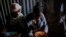 FILE - Displaced Tigrayan women sit in a metal shack to eat food donated by local residents at a reception center for the internally displaced in Mekele, in the Tigray region of northern Ethiopia, on May 9, 2021.