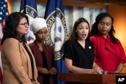 FILE - U.S. Rep. Alexandria Ocasio-Cortez, D-N.Y., speaks as, from left, Rep. Rashida Tlaib, D-Mich., Rep. Ilhan Omar, D-Minn., and Rep. Ayanna Pressley, D-Mass., listen during a news conference at the Capitol in Washington, July 15, 2019.