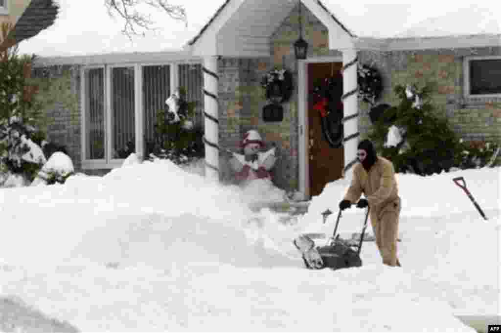 Chris Wierzbicki clears snow from the side walk in front of his house in the Howard Beach neighborhood of the Queens borough of New York, Tuesday, Dec. 28, 2010. (AP Photo/Mary Altaffer)