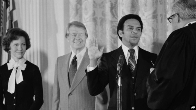 ARCHIVO - Andrew Young es juramentado como embajador ante las Naciones Unidas por el juez asociado Thurgood Marshall, mientras el presidente Jimmy Carter observa en la Casa Blanca, el 31 de enero de 1977 en Washington.