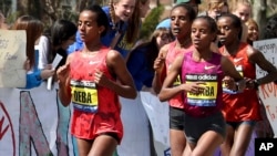 Buzunesh Deba, à gauche, d'Éthiopie, participe au 118e marathon de Boston à Wellesley, au Massachusetts, le 21 avril 2014.