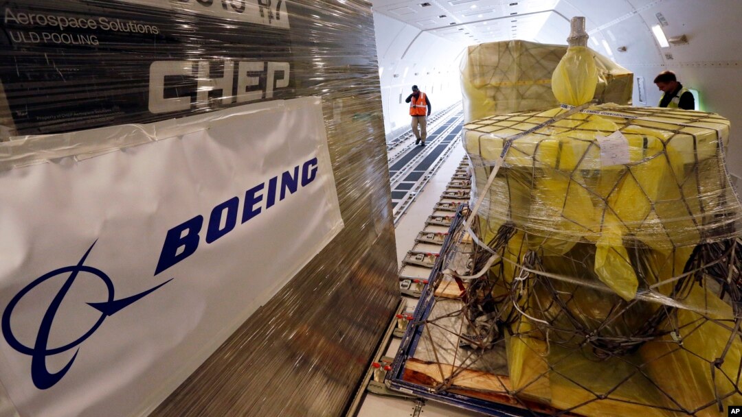 FILE - Workers move cargo into position inside a new AirBridgeCargo Boeing 787-8 freighter airplane, Oct. 7, 2016, at Seattle-Tacoma International Airport.