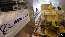 FILE - Workers move cargo into position inside a new AirBridgeCargo Boeing 787-8 freighter airplane, Oct. 7, 2016, at Seattle-Tacoma International Airport.