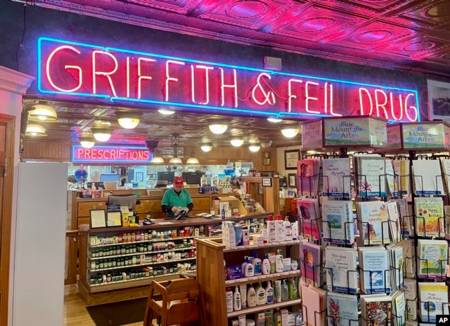 A man works behind the pharmacy counter at Griffith & Feil Drug on Thursday, March 30, 2023, in Kenova, W. Va. Soda fountains were often in pharmacies because pharmacists mixed tonics meant to heal ailments. (AP Photo/John Raby)