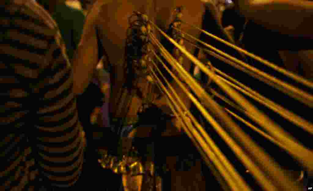 Body piercings are symbols of sacrifices that the devotees make on Thaipusam. It is believed that the more piercings one do to his body, the more reward will be given to him. (VOA - Yong YN)