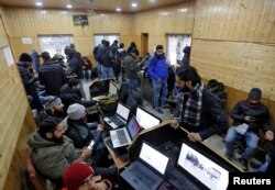FILE - Journalists use the internet as they work inside a government-run media center in Srinagar Jan. 10, 2020.