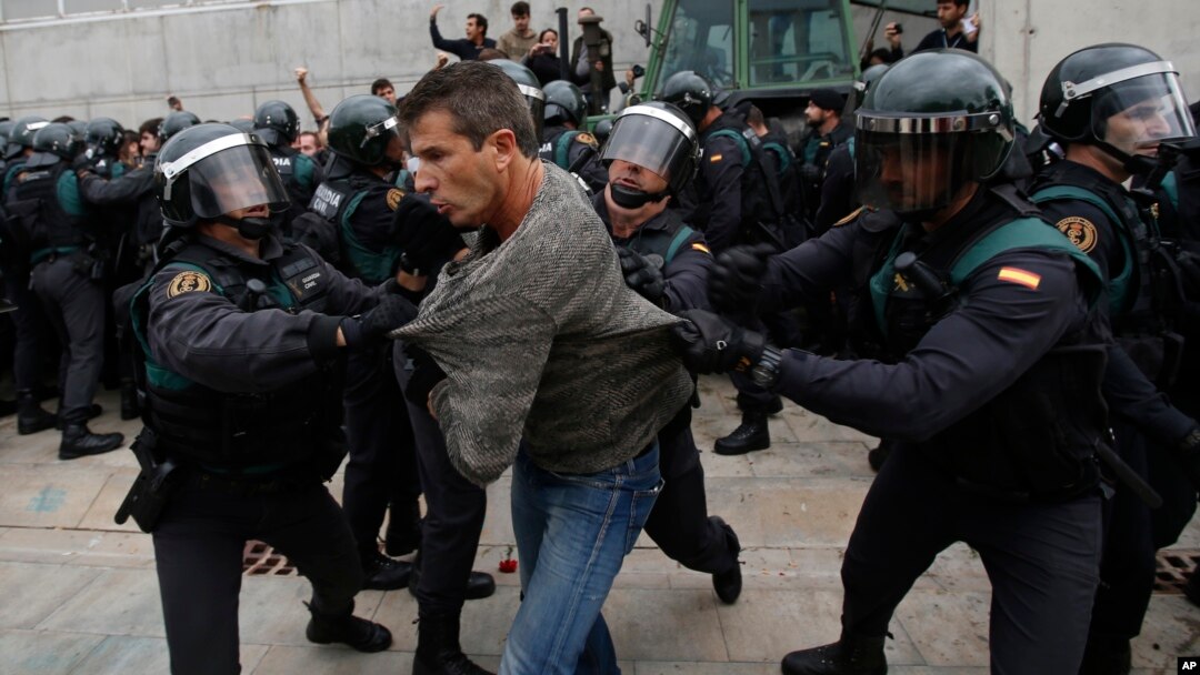 Para pemilih referendum kemerdekaan Catalonia terlibat bentrokan dengan polisi, saat memberikan suara di Girona, Spanyol Minggu (1/10). 