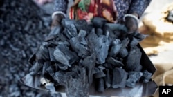 FILE - A woman works at a coal depot in Ahmedabad, India, May 2, 2022.