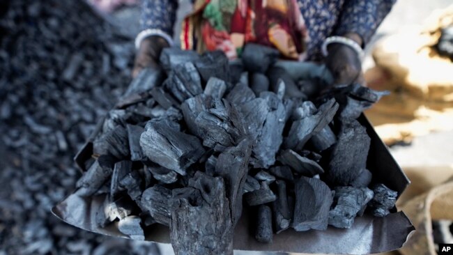 FILE - A woman works at a coal depot in Ahmedabad, India, May 2, 2022.