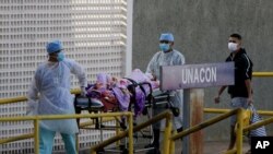 Health workers receive a new patient suspected of COVID-19 arriving at the University Hospital of Brasília, in Brasilia, Brazil, Aug. 5, 2020.