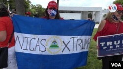 Una mujer sostiene una bandera nicaragüense con un mensaje de apoyo a Trump en Miami. Foto: Antoni Belchi.