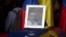 A framed portrait of opposition activist Fernando Alban shadowed by an image of Jesus Christ sits on the flag-draped casket containing his remains, during a solemn ceremony at the National Assembly headquarters, Caracas, Venezuela, Oct. 9, 2018. 
