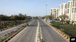 A commuter walks on a deserted street during a day long lockdown amid growing concerns of coronavirus, in New Delhi, India, March 22, 2020.