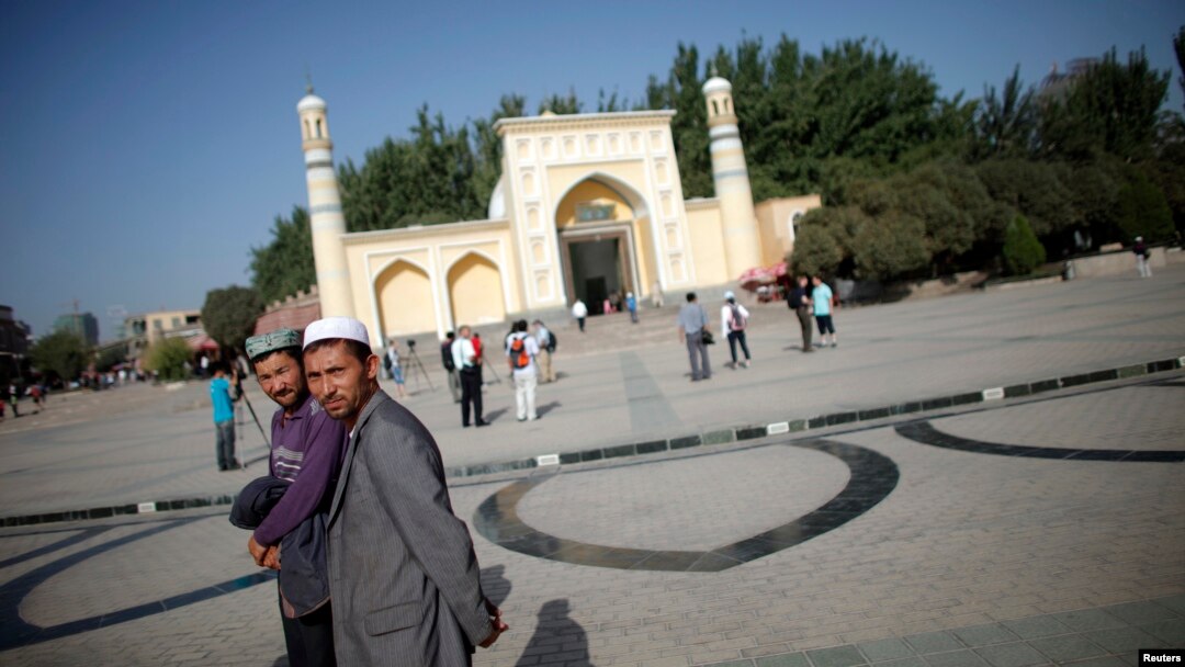 Người Uighur đi bộ bên ngoài một nhà thờ Hồi giáo ở Kashgar, Tân Cương.