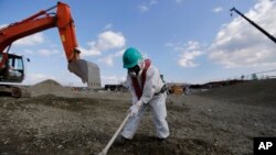 Seorang pekerja mengenakan pakaian pelindung dan masker, memeriksa PLTN Dai-ichi di Fukushima yang dioperasikan oleh TEPCO di Okuma, Fukushima (10/2). 