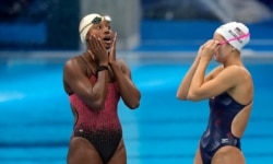 Simone Manuel de EE.UU., izquierda, reacciona con su compañera de equipo Katie McLaughlin, derecha, en la piscina durante una sesión de entrenamiento de natación en el Centro Acuático de Tokio en los Juegos Olímpicos de Verano, el 21 de julio de 2021