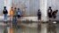 Palestinian children try to cross a waste water - flooded street in Gaza City, Nov. 14, 2013. 