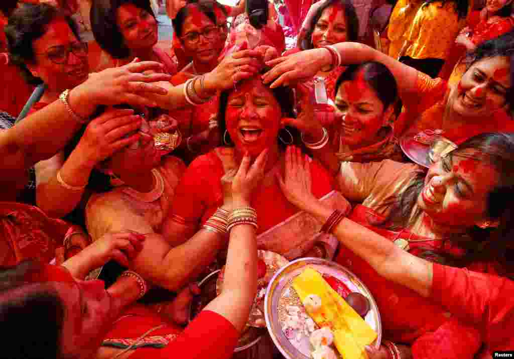 A Hindu woman reacts as &quot;Sindhur,&quot; or vermilion powder, is applied to her face after worshiping an idol of the Hindu goddess Durga on the last day of the Durga Puja festival in Chandigarh, India.