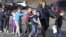 In this photo provided by the Newtown Bee, Connecticut State Police lead children from the Sandy Hook Elementary School in Newtown, Conn., following a reported shooting there, Dec. 14, 2012. 