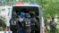 FILE - Riot policemen lead men who are about to be executed into a police van in this still image taken from video in an unknown location in the Xinjiang Uighur Autonomous Region.