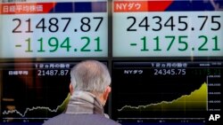 Seorang pria melihat indeks saham pada sebuah monitor di Tokyo, Jepang (foto: dok). 