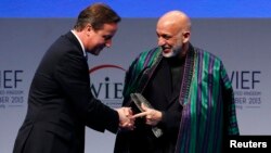 Perdana Menteri Inggris David Cameron menyambut Presiden Afghanistan Hamid Karzai dalam pertemuan di Forum Ekonomi Islamis di London. (Foto: Dok)