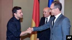 Ukrainian President Volodymyr Zelenskiy (L) greets German Foreign Minister Heiko Maas and French Foreign Minister Jean-Yves Le Drian during a meeting in Kyiv, Ukraine, May 30, 2019.