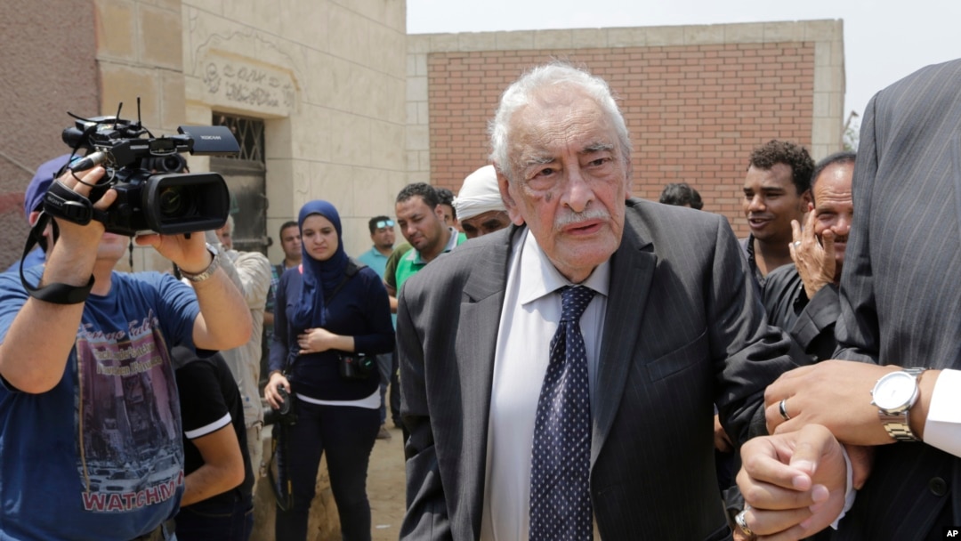 FILE - Egyptian actor Gamil Ratib is helped by a relative as he attends Omar Sharif's burial at the El Shafie Cemetery in Cairo, Egypt, Sunday, July 12, 2015. 