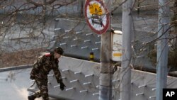 Fermeture d'une route menant aux ambassades dans le quartier de Sanlitun à Pékin, le jeudi 24 décembre 2015.
(AP Photo/Ng Han Guan)