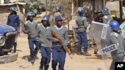 FILE: Armed Zimbabwean police battle rioters in Harare, Monday, July, 4, 2016. (AP Photo/Tsvangirayi Mukwazhi)